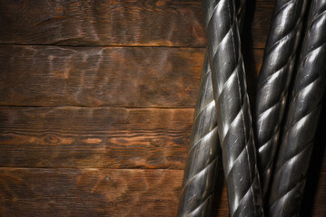 Two twisted steel pipes framing empty space on wooden workbench table top view background with copy space.