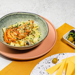 Creamy Chicken Pasta with Mushrooms, Pine Nuts, and Grated Cheese in a Rustic Ceramic Bowl