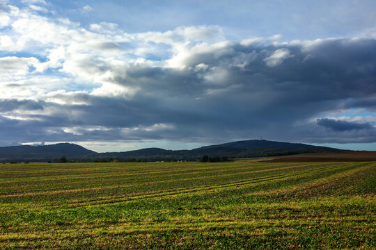 Autumnal rural landscape with Sleza, Radunia and Wiezyca mountains in Sudetes, Lower Silesia, Poland. Agricultural field in foreground.
