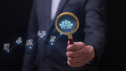 Focused HR process optimization with businessman holding magnifying glass analyzing recruitment data