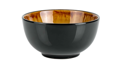 A close-up shot of a glossy, dark-colored bowl. The inner surface exhibits a warm, brown glaze. It sits against a black background