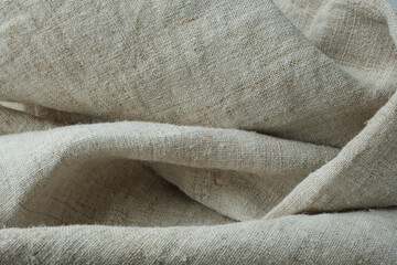 Folded hemp fabric. Rough, undyed hemp canvas. Selective focus.