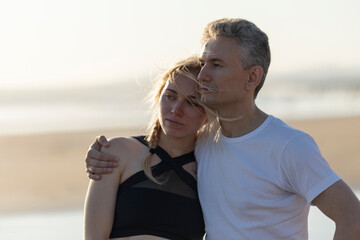 Couple embracing outdoors looking away pensive moment