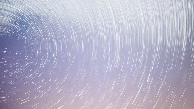 Forming circular star trails, stars lengthening arcs across stacked exposures over low horizon glow