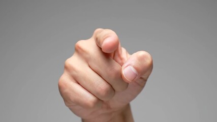 Human hand pointing towards viewer on a neutral background