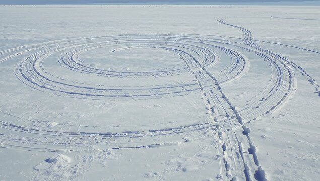 Forming concentric snow tracks carving rings on frozen lake, showing parallel ruts and snow blocks - Powered by Adobe