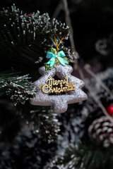  Festive Charm Ornament: A close-up shot of a glittery, tree-shaped ornament embellished with a cheerful Merry Christmas message, adding festive spirit to the holiday season.