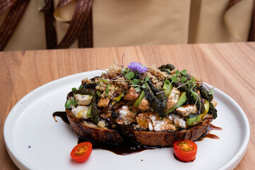 Gourmet Toast with Greens: A culinary creation featuring a slice of toasted bread crowned with a vibrant medley of fresh greens and savory ingredients, artfully presented on a pristine plate.