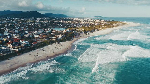 Aerial view of the Brazilian coast with sandy beach living buildings and wavy Atlantic Ocean. Florianopolis, Santa Catarina