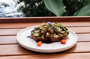 Savory Delight on a Plate: A beautifully presented open-faced sandwich, topped with a gourmet array of mushrooms, fresh herbs, and a drizzle of rich sauce.