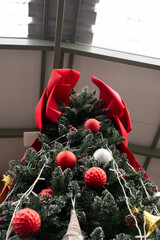 Festive Christmas Tree with Red Bow: A Christmas tree, adorned with shimmering ornaments and a bold red bow, stands tall, radiating festive cheer and seasonal delight. 