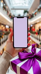 Hand holding a phone and a gift in a christmas mall.