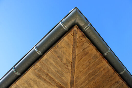 Goutti&egrave;re zinc gris sur la fa&ccedil;ade de la maison et sous-face en lambris bois