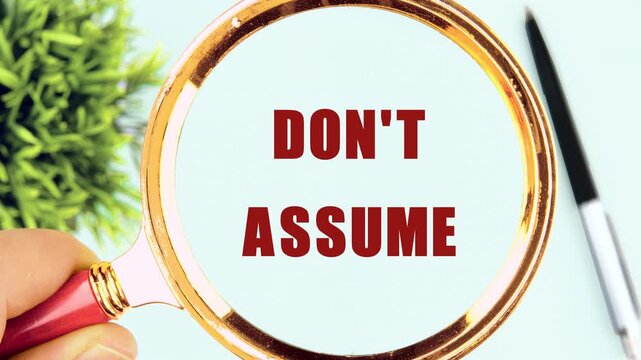 Animation, the appearance of a conceptual phrase, words, symbols DON'T ASSUME through a magnifying glass
