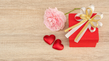 Red gift box and pink rose flower for a Valentine's Day festival.