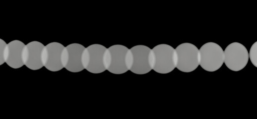 Monochrome blurred lights create a continuous horizontal row of bokeh circles on a black background.