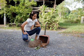 Woman sweeping the area in front of the house.