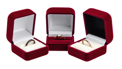 Three burgundy velvet ring boxes with rings inside, displayed against a stark black background