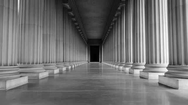 Black and white dolly shot in long corridor with classic columns