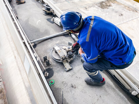 Oil Tank Truck Hatch Inspection by Industrial Worker