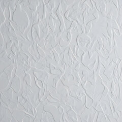A close-up view of a white textured surface with intricate patterns and embossed designs in a neutral environment