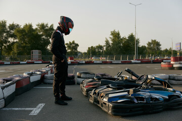 A professional drive racer is posing with cars near at the race