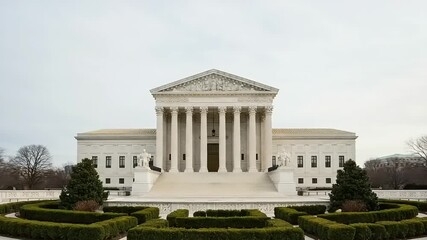The United States Supreme Court Building in Washington D.C. on a cloudy day, a symbol of American justice and law.