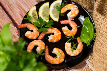 Boiled red shrimps with lemon on a wooden table