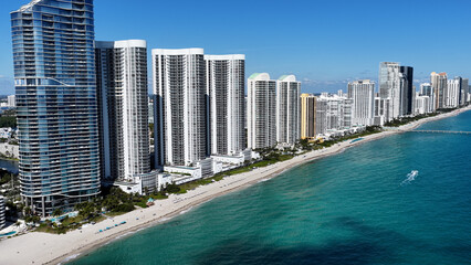 Naklejka premium Sunny Isles Skyline At Sunny Isles Beach In Florida United States. Beach Landscape. Downtown District. Travel Destination. Sunny Isles Skyline At Sunny Isles Beach In Florida. Nature Seascape.