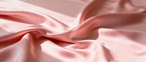 Fototapeta premium Ultra-wide 4:1 shot of softly folded blush-pink silk fabric creating elegant waves and highlights, luxurious romantic texture, no objects. Soft studio lighting with gentle shadows. High-end editorial 