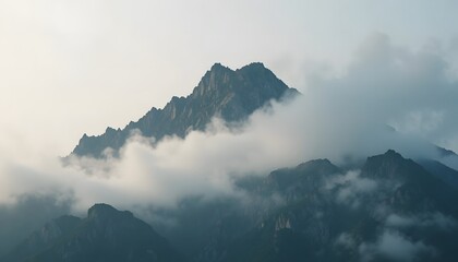  Close-up of a mountain peak partially covered in morning fog.