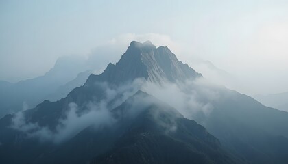  Close-up of a mountain peak partially covered in morning fog.
