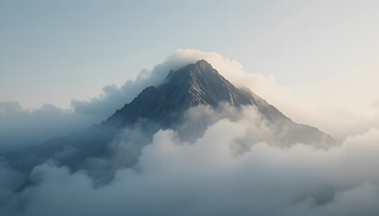  Close-up of a mountain peak partially covered in morning fog.