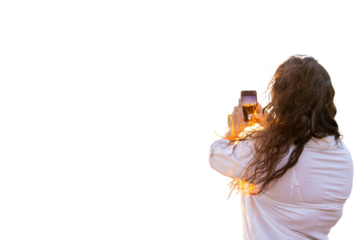 Woman engineer taking photos of eolic park with smartphone at sunset. PNG background