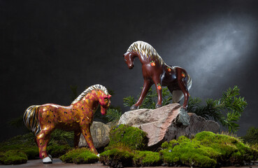 Two porcelain sculptures of horses among stones. Still life for the Year of the Horse
