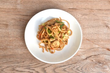 fried Chinese noodles slice chicken and celery in soy sauce on plate 