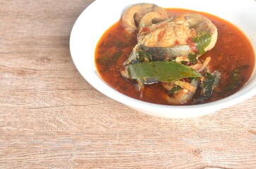 spicy chili boiled catfish with eggplant and basil in curry soup on bowl
