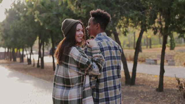 Back side view young couple two friends family man woman wear casual clothes together hug put head on shoulder walk rest relax in fall city park go down alley outdoors on nature. Urban leisure concept