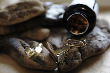 Omega 3 fish oil capsules and a brown bottle on wood surfaces. Nutritional supplement for healthy...