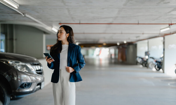 Businesswoman searching parking spot holding smartphone