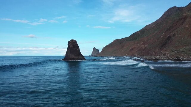 Aerial view of the dramatic Roque de Benijo rock formations rising from the deep blue sea, contrasting with the rugged coastline, Benijo, Santa Cruz de Tenerife, Spain.