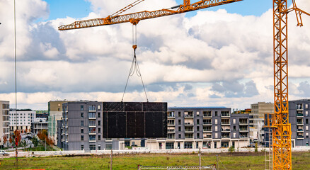 Residential Construction Site With Tower Cranes: New Apartment Buildings Rising In Urban Development Area Under Cloudy Sky