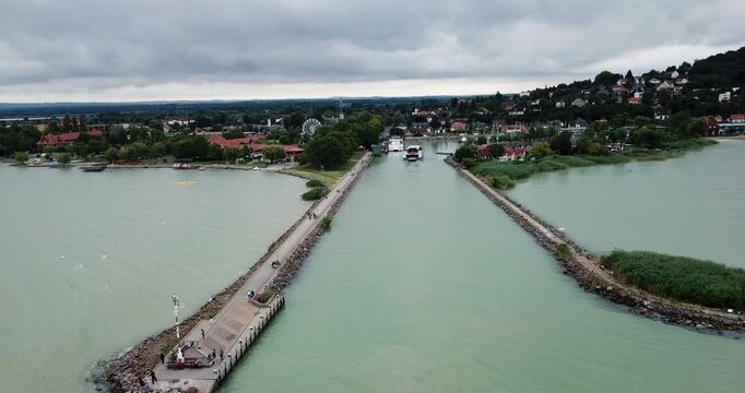 Aerial view of the Fonyod pier stretching out into Lake Balaton with its distinctive breakwaters, under a cloudy sky, Fonyod, Fonyod, Hungary.