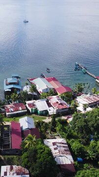 Vertical aerial view of Bastimentos Island in Panama&rsquo;s Bocas del Toro, featuring lush greenery and coastal homes.