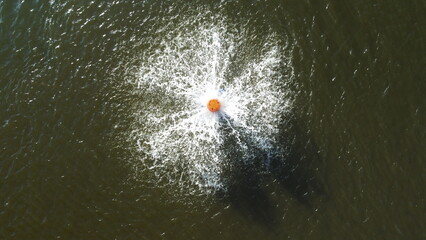 Aerial view of water aerators creating circular splashes on a green water surface. Abstract pattern representing water treatment, environmental management, sustainability, and clean water concepts.
