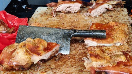 Crispy Roasted Pork Belly (Babi Guling or Lechon) Being Chopped on a Gritty Butcher's Cutting Board with a Cleaver