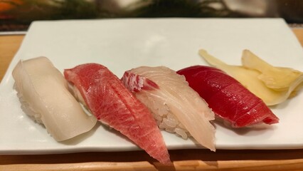Assortment of High-Quality Nigiri Sushi on a White Plate with Pickled Ginger