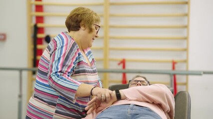 Female physical therapist helping a senior patient with arm mobility exercises in a rehabilitation center. Elder care and physiotherapy concept - Powered by Adobe