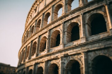 Fototapeta premium Ancient stone amphitheater structure curves upward toward a pale sky