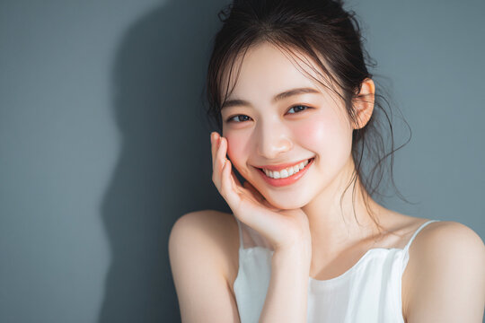 笑顔できらめく綺麗な肌と白い歯を見せる日本人女性美人モデルの接写写真。オーラルケア、スキンケア、コスメ広告用。